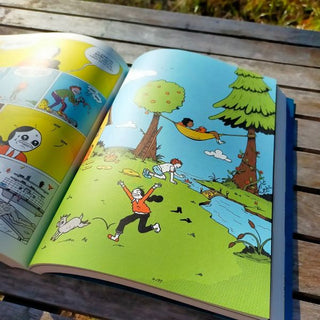 Open book with colorful illustrations of children playing outdoors.