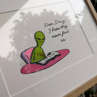 Cartoon alien writing in a book with text 'Dear Diary, I hope they never find us' on a white background.