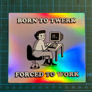 A holographic sticker featuring a cartoon office worker sitting at a retro computer desk with a monitor. The worker has a resigned expression while typing. Above the character, bold 3D letters spell ‘BORN TO TWERK’, and below, ‘FORCED TO WORK’. The sticker has a rainbow iridescent finish that shimmers in the light, and is placed on a grid background for scale. Perfect for fans of dark office humor, meme culture, and ironic desk decor—this waterproof, durable sticker is ideal for laptops, water bottles.