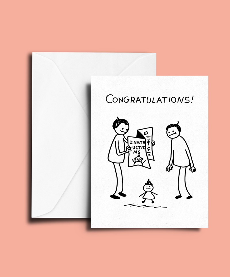 A white greeting card with a black hand-drawn stick figure illustration and the word 'CONGRATULATIONS!' at the top, shown with a matching white envelope on a peach-pink background.