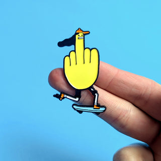hand holding funny skater pin, yellow skateboard middle finger